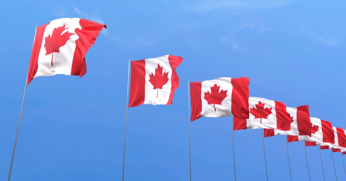 Canadian flags against a blue sky