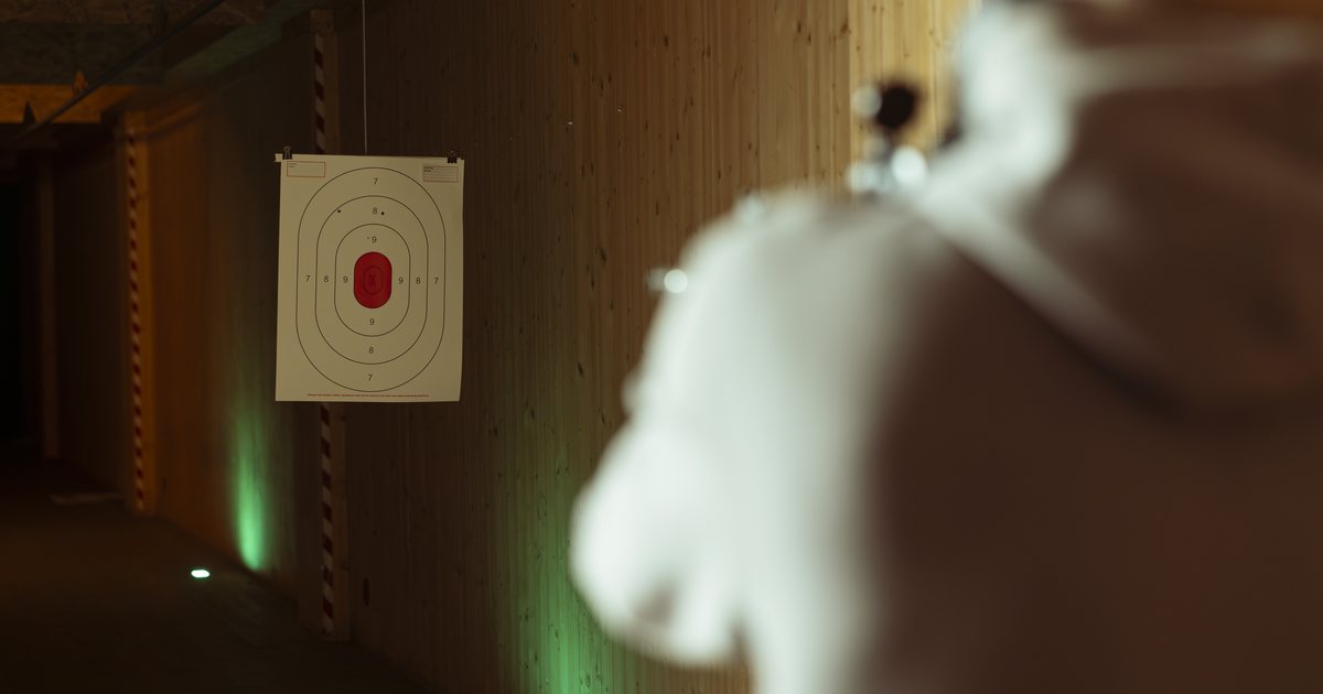 A participant facing a target at an indoor range