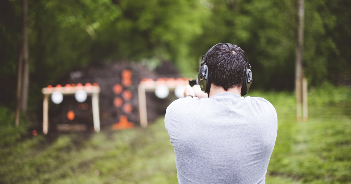 A man wearing hearing protection at an outdoor range