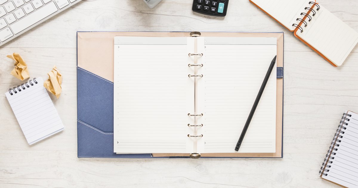 An open paper organizer and pen on a desk