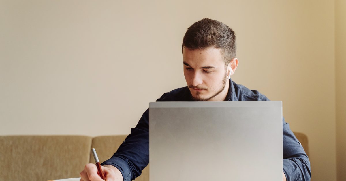 A man studying at home with a laptop
