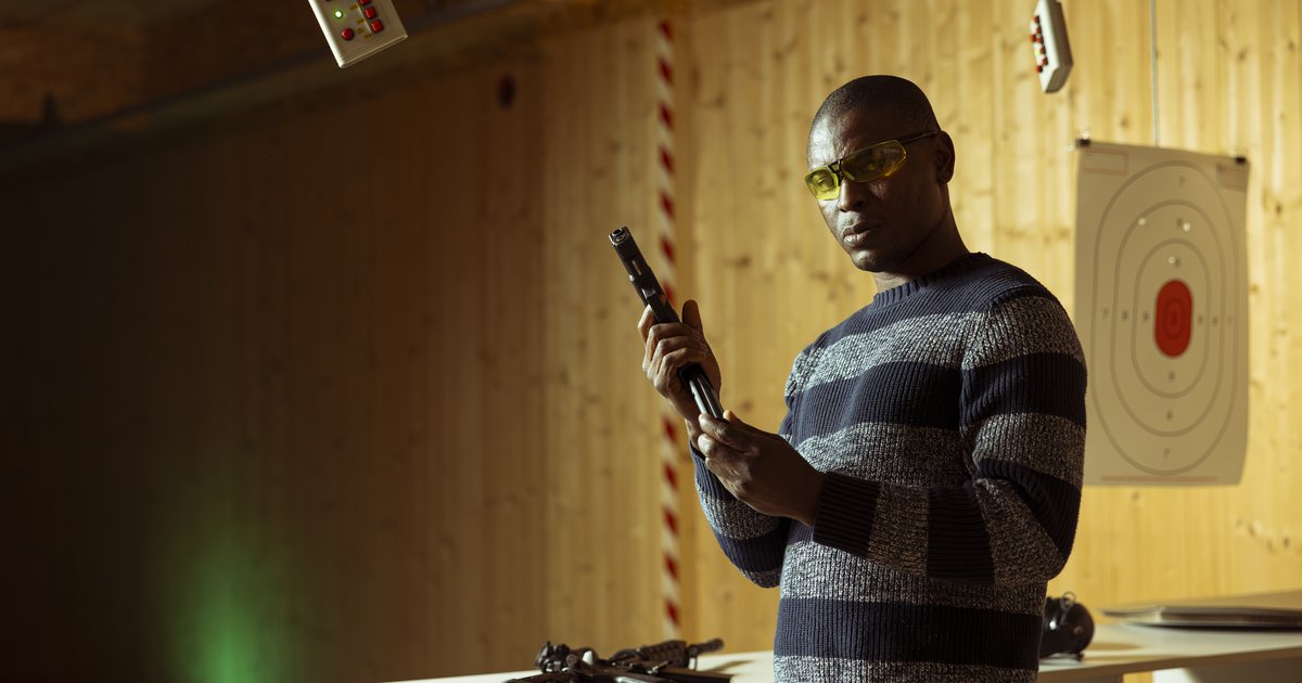 A man wearing eye and hearing protection at an indoor range